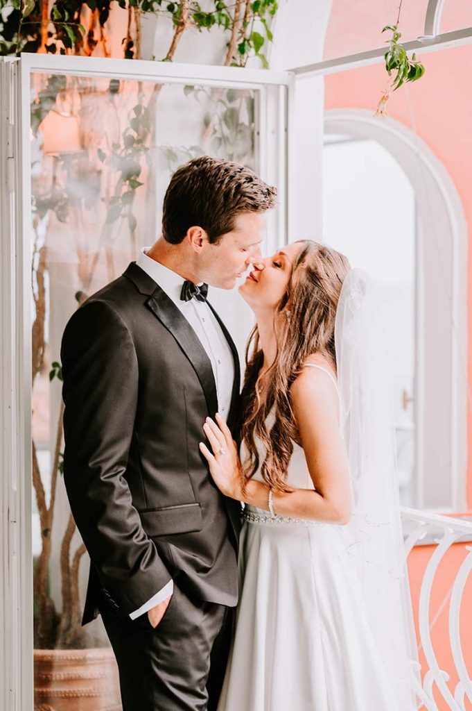 Bride and groom sharing a kiss near a window, captured by an Amalfi Coast wedding photographer.