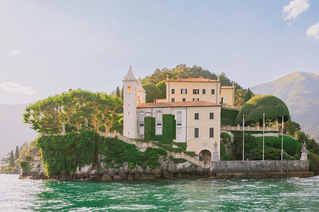 The iconic Villa del Balbianello surrounded by lush greenery on the shores of Lake Como, a true hidden gem in Lake Como