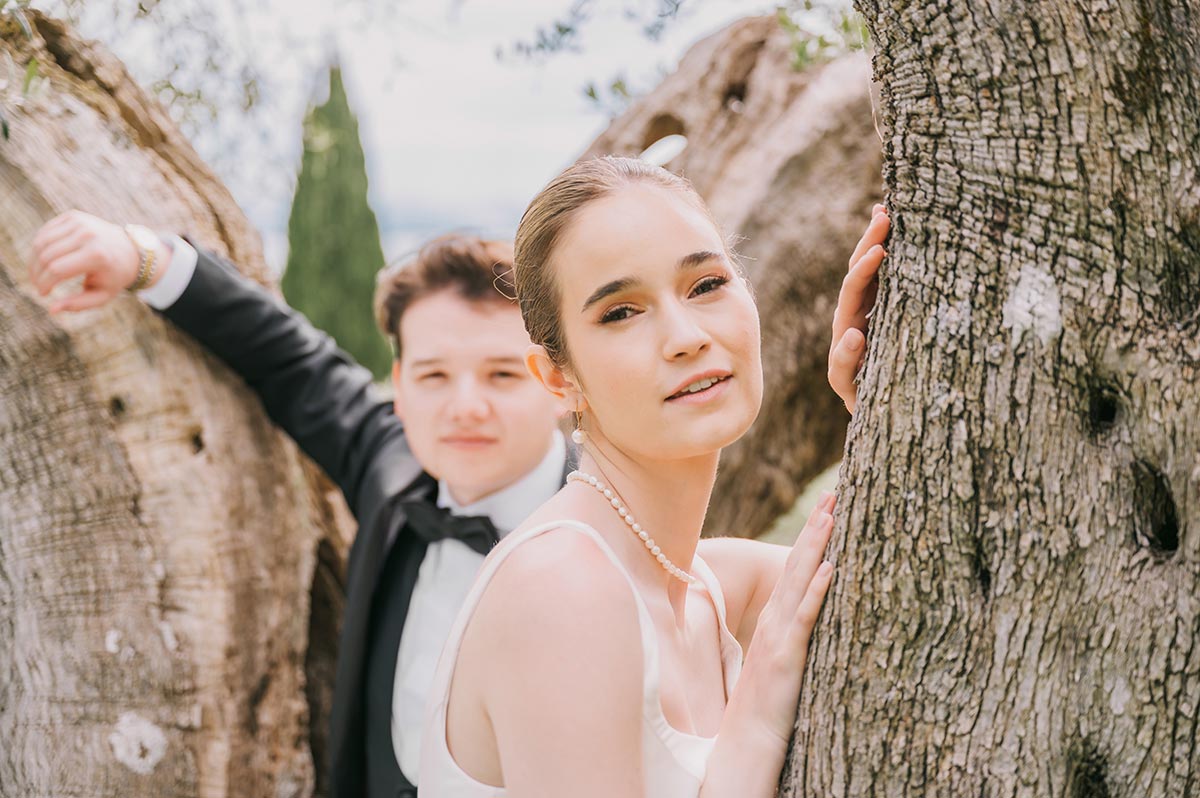 Close-up of a bride and groom framed by tree trunks in a romantic Amalfi setting