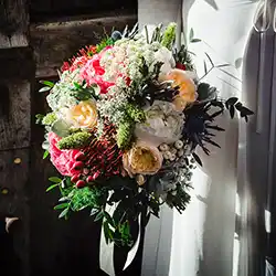 A vibrant wedding bouquet with roses and greenery, perfect for a rustic chic wedding in Tuscany on a budge