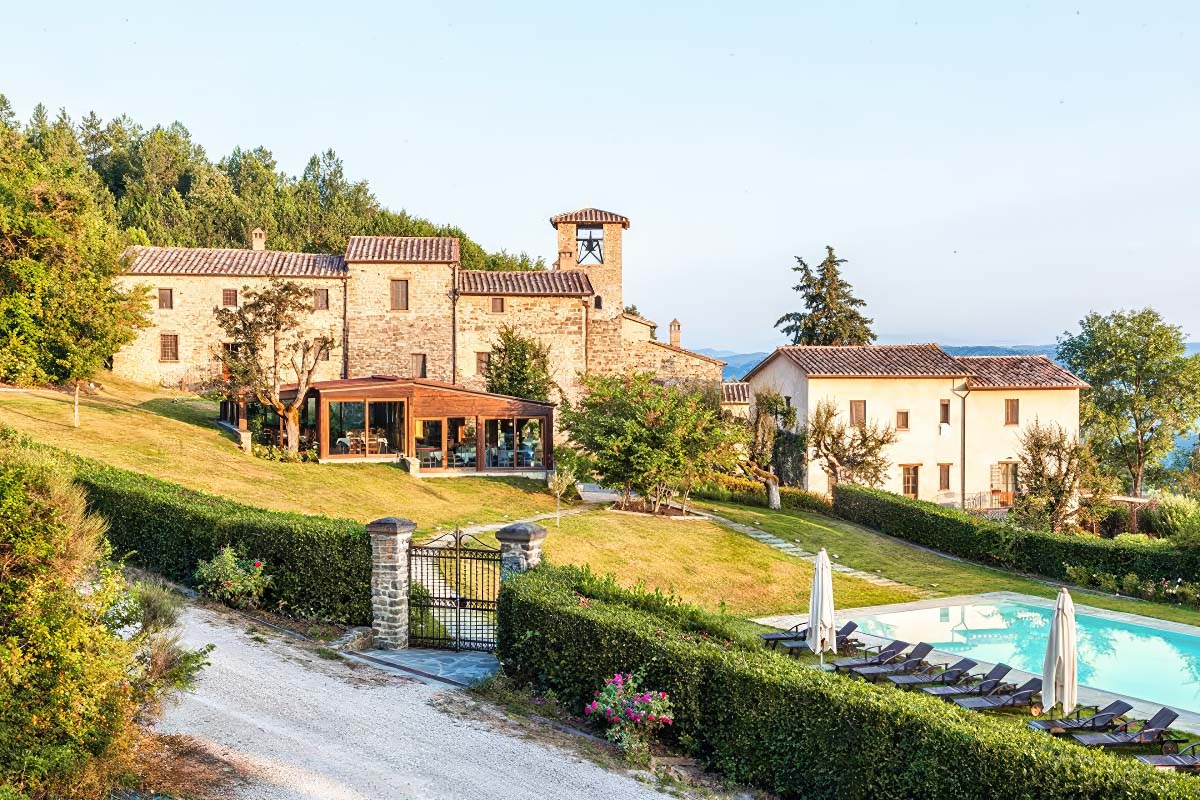 A picturesque and affordable Tuscan wedding venue featuring a rustic villa, lush gardens, and a pool, surrounded by rolling hills